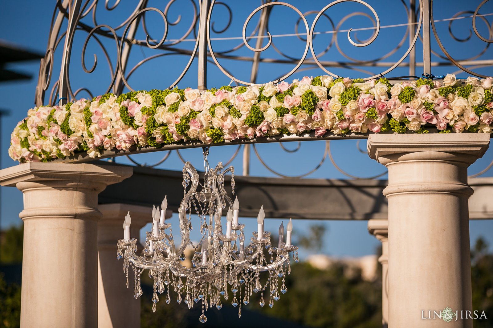 Floral garland over columns with crystal chandelier